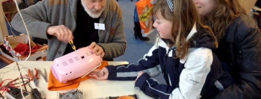 Oudere heer repareert speelgoed van meisje
